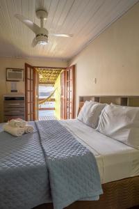 阿拉夏奇巴海滩Pousada Cruzoé的一间卧室配有一张大床和毛巾