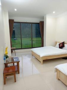 Mù Cang ChảiHomestay Hoà Thảo的一间卧室设有两张床和大窗户
