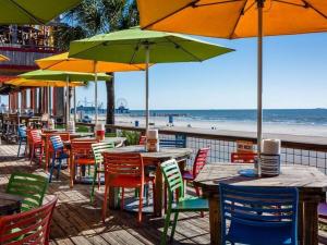 加尔维斯敦The Q Loft Galveston的海滩上一组桌椅和遮阳伞