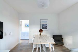 斯瓦讷克Holiday Apartment At Beautiful Solgaarden 8的白色的用餐室配有桌椅