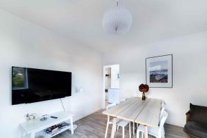 斯瓦讷克Holiday Apartment At Beautiful Solgaarden 8的白色的客厅配有桌子和电视。