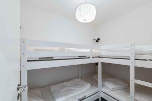 斯瓦讷克Holiday Apartment At Beautiful Solgaarden 8的一间设有白色双层床和光线的房间