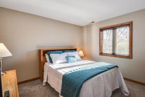 加利纳Cozy Illinois Abode with Deck and Grill, Near Golfing!的一间卧室配有一张带蓝色枕头的床和一扇窗户。