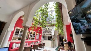 塞维利亚摩尔国王精品酒店的餐厅设有红色的墙壁和桌椅