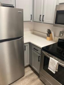 匹兹堡Home Street at Bracken House的厨房配有不锈钢冰箱和白色橱柜