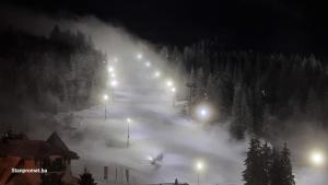亚霍里纳Sun&Snow Jahorina的雪覆盖的滑雪场,晚上有灯光