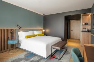 波尔图Renaissance Porto Lapa Hotel的卧室配有一张白色大床和一把椅子
