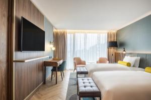 波尔图Renaissance Porto Lapa Hotel的酒店客房配有两张床和一张书桌