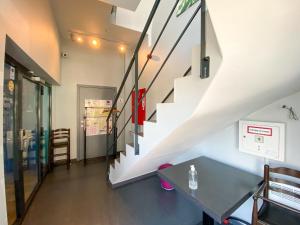 Auvelais阿弗勒尔日库埃特酒店的一间设有楼梯和桌子的房间