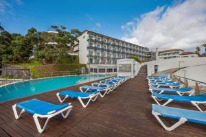 英雄港杜卡拉科尔酒店的游泳池旁的一排蓝色和白色的躺椅
