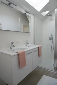 尼乌波特Casa Maris - Het huis van de zee - Viersterrenverblijf的白色的浴室设有两个盥洗盆和镜子