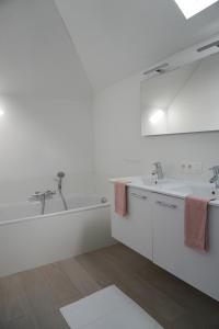 尼乌波特Casa Maris - Het huis van de zee - Viersterrenverblijf的白色的浴室设有2个盥洗盆和1个浴缸。