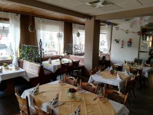 Reichshof Hotel-Restaurant Denklinger-Hof的餐厅设有白色的桌椅和窗户。