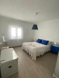 CanoFerroa Guest House的白色卧室配有蓝色枕头的床