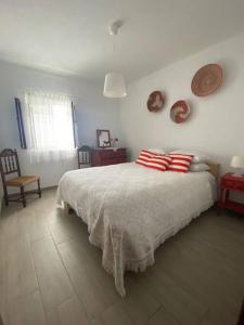 CanoFerroa Guest House的一间卧室配有红色和白色枕头的床