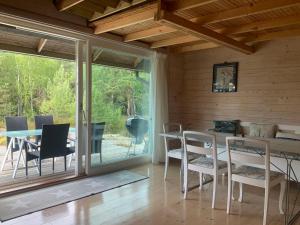 IngmarsöCozy Cabin in Stockholms Archipelago的一间带桌椅的用餐室和一个庭院