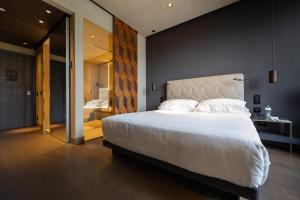 米兰Hotel VIU Milan, a Member of Design Hotels的一间带白色大床的卧室和一间浴室