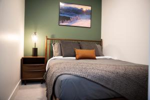 雷夫尔斯托克Powder & Pines - Cozy 2 Bedroom with Hot Tub的一间卧室配有一张带橙色枕头的床