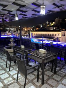 安曼Downtown Hawaa Amman Hotel的一间设有桌椅的餐厅,享有城市美景