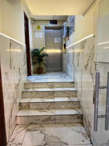 安曼Downtown Hawaa Amman Hotel的走廊上设有楼梯,门上设有盆栽