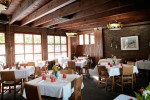 比林斯多德牧野别墅酒店的一间设有白色桌椅和窗户的用餐室