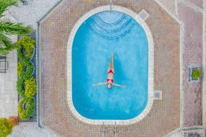 棕榈滩MVC鹰湾酒店的在游泳池游泳的人,戴着圣帽