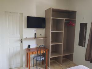 马瑙斯VilaVerin Apartments的客房设有带电视和书架的书桌。