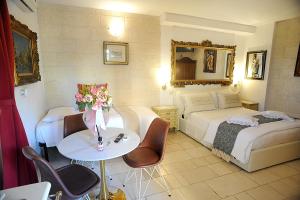 法萨诺吉安鲁斯住宿加早餐旅馆的酒店客房,设有两张床和一张鲜花桌。