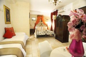 法萨诺吉安鲁斯住宿加早餐旅馆的一间带两张床的卧室和鲜花花瓶