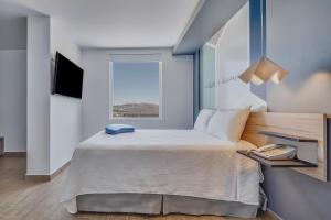 莫雷利亚One Morelia Acueducto的一间卧室设有一张大床和一个窗户。