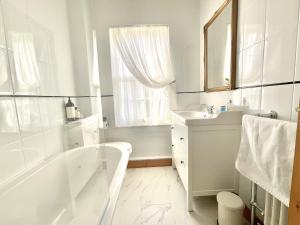 锡廷伯恩Green Cottages的白色的浴室设有浴缸和水槽。