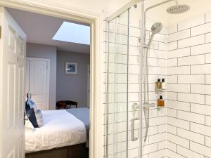 锡豪西斯Beach House Hotel的带淋浴的浴室和客房内的一张床