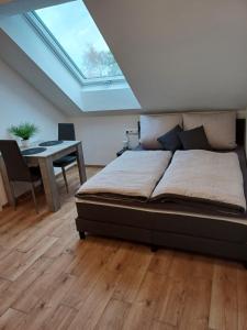吉贝尔施塔特Bianca's Ferienwohnungen的一间卧室配有一张床和一张书桌,天窗