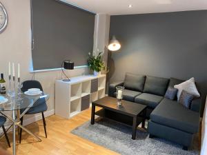 谢菲尔德City Centre Modern Studio Apartment - Westone FREE WIFI, GYM ACCESS, NETFLIX的客厅配有沙发和桌子