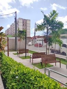 累西腓Apê da Mel - Recife PE的公园里长着一排长椅,有树木和建筑物