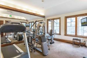 比弗河Saddleridge Villas #3的一个带跑步机和椭圆机的健身房,位于带窗户的房间内