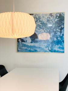 霍森斯Scandinavian House Hotel-Lunden- Central 3 bedroom house的挂在桌子上的一盏灯,墙上挂着一幅画