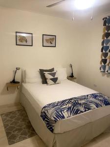 基督教堂市Private 3BR Tropical Paradise near Oistins的一间卧室配有一张大床和枕头