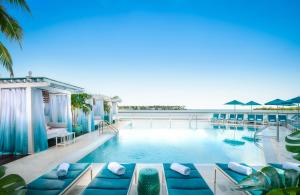 基韦斯特海洋之匙贵族山庄Spa度假酒店的一个带蓝色家具的游泳池,享有海景