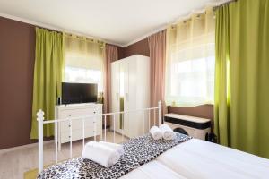 布达佩斯Barbarosa Sweet Dream 3的一间卧室配有床、电视和绿色窗帘