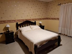 圣米格尔·德·图库玛Marcos Paz temporario的一间卧室配有一张床和两个带灯的床头柜