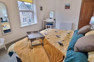 Burley in WharfedaleDale Cottage Cozy 3 Bedroom nr Ilkley - West Yorkshire的一间设有一张桌子和一张床铺的房间