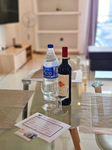 丰沙尔Anadia Atrium的桌子上放一瓶水和一杯葡萄酒