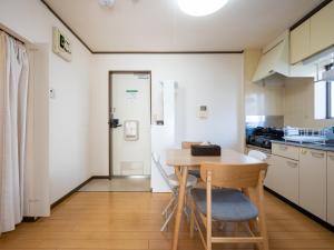 东京maison elegance - Vacation STAY 15799的一个带木桌和椅子的小厨房