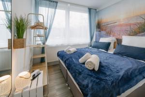 拜罗伊特Modernes 2-Zimmer Themen-Apartment "Meereslust" im Zentrum的一间卧室配有蓝色的床和毛巾