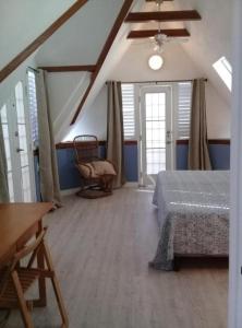 西班牙港Trinidad Gingerbread House的一间卧室,卧室内配有一张床和一把椅子