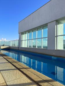 巴西利亚SM622 Flat região central Próx Embaixada Americana的一座建筑前面设有游泳池