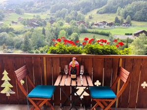 瓦尔·蒂利兹Apparthotel Mountain River Resort的一张桌子、一瓶葡萄酒和两把椅子