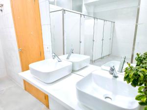瓦伦西亚CAPSULE INN VALENCIA Hostel的浴室设有2个水槽和镜子