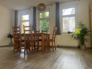 弗赖贝格Bergstadtwohnung的一间带木桌和椅子的用餐室